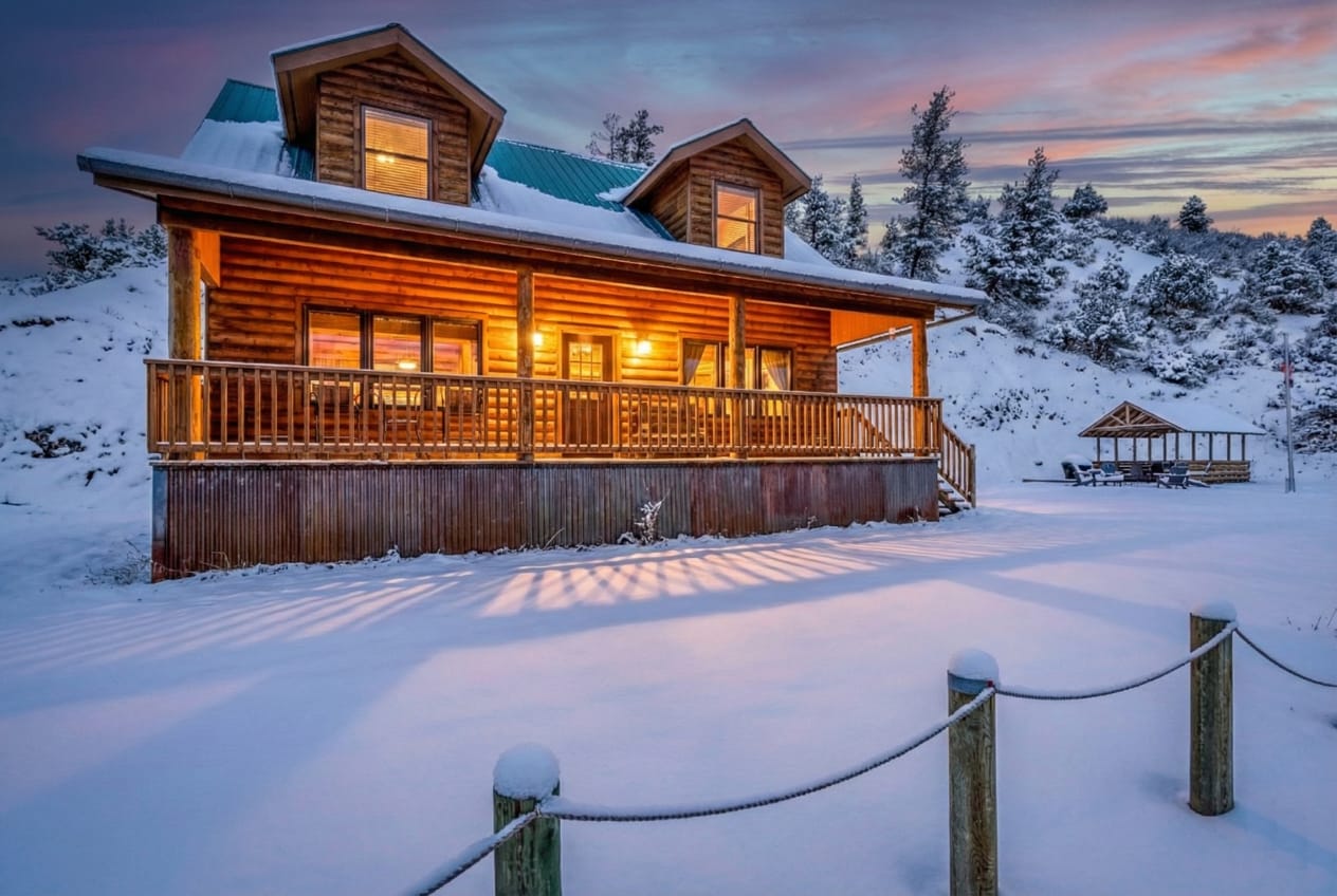 Big dormers, warm windows, logs that mean it.